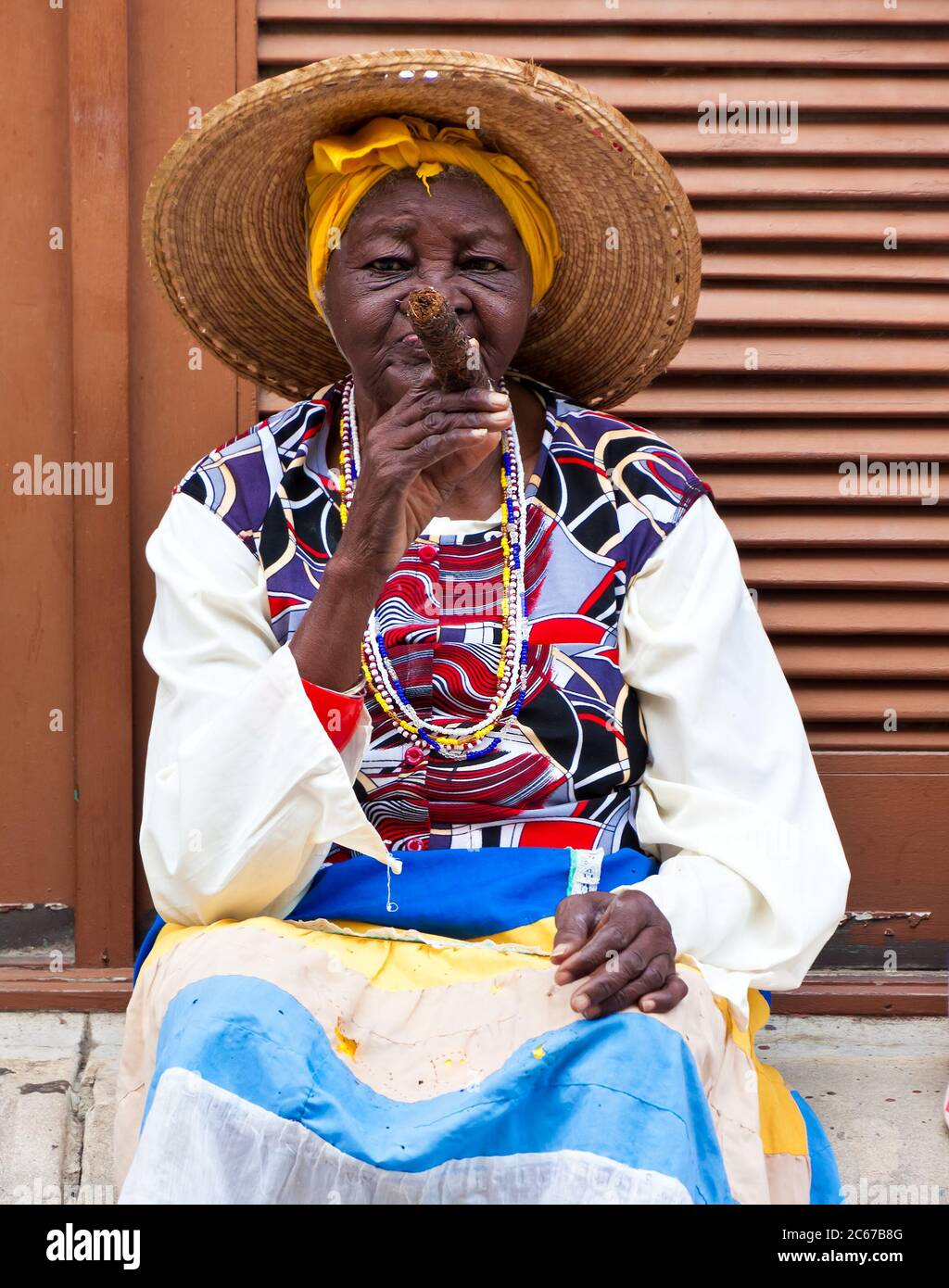 Elderly black woman smoking a cuban cigar in Old Havana Stock Photo