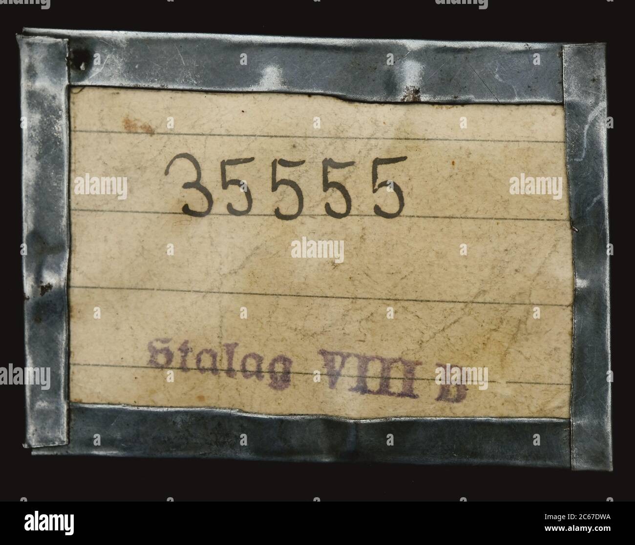 Prisoner of War number written on paper and encased in a homemade frame of plastic and tin. Lambsdorf POW camp Stalag VIIIB WW2 Stock Photo