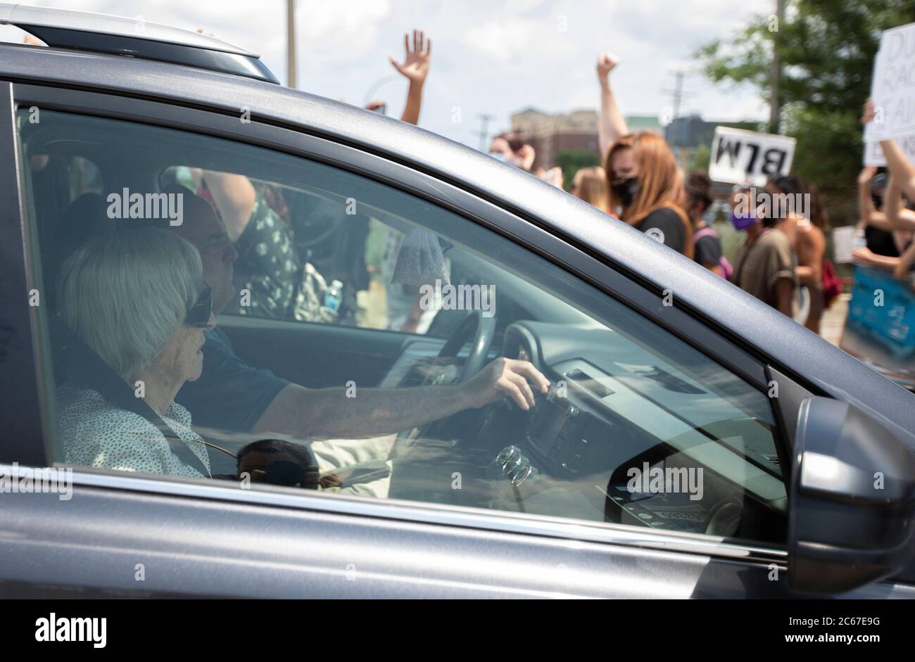 July 5, 2020: Protesters walk by a vehicle in Bloomington, Minnesota as the passengers watch while they made their way from the Mall of America in Bloomington to Geroge Floyd Square in Minneapolis on July 5, 2020. (Credit Image: © Chris JuhnZUMA Wire) Stock Photo
