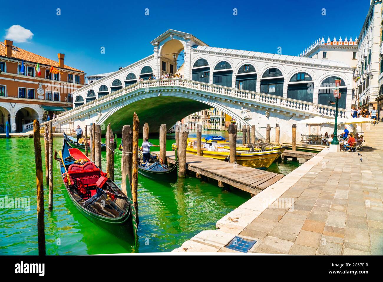 Venice, Italy - june 29th 2020 - very little tourists crossing the Grand Canal over the Rialto bridge (Ponte di Rialto) with workless gondolier on a s Stock Photo