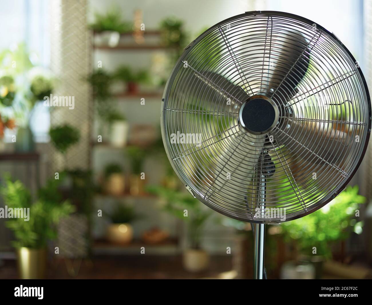 Summer heat. modern metallic floor stand electric fan at modern home in