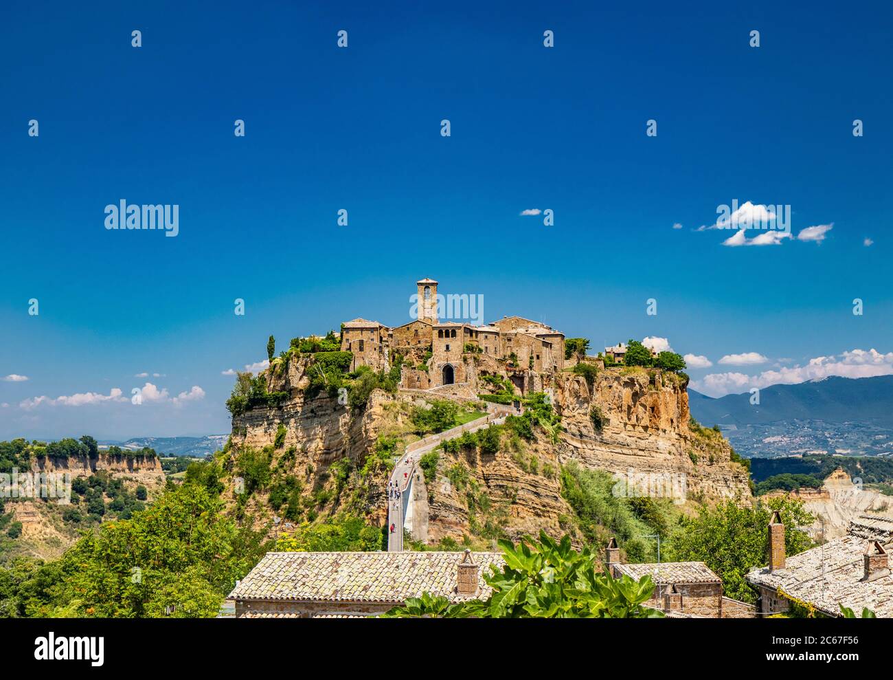 View of the medieval town of Civita di Bagnoregio, located on the top of a spur of tuff rock, in the middle of the valley of the badlands. Connected t Stock Photo