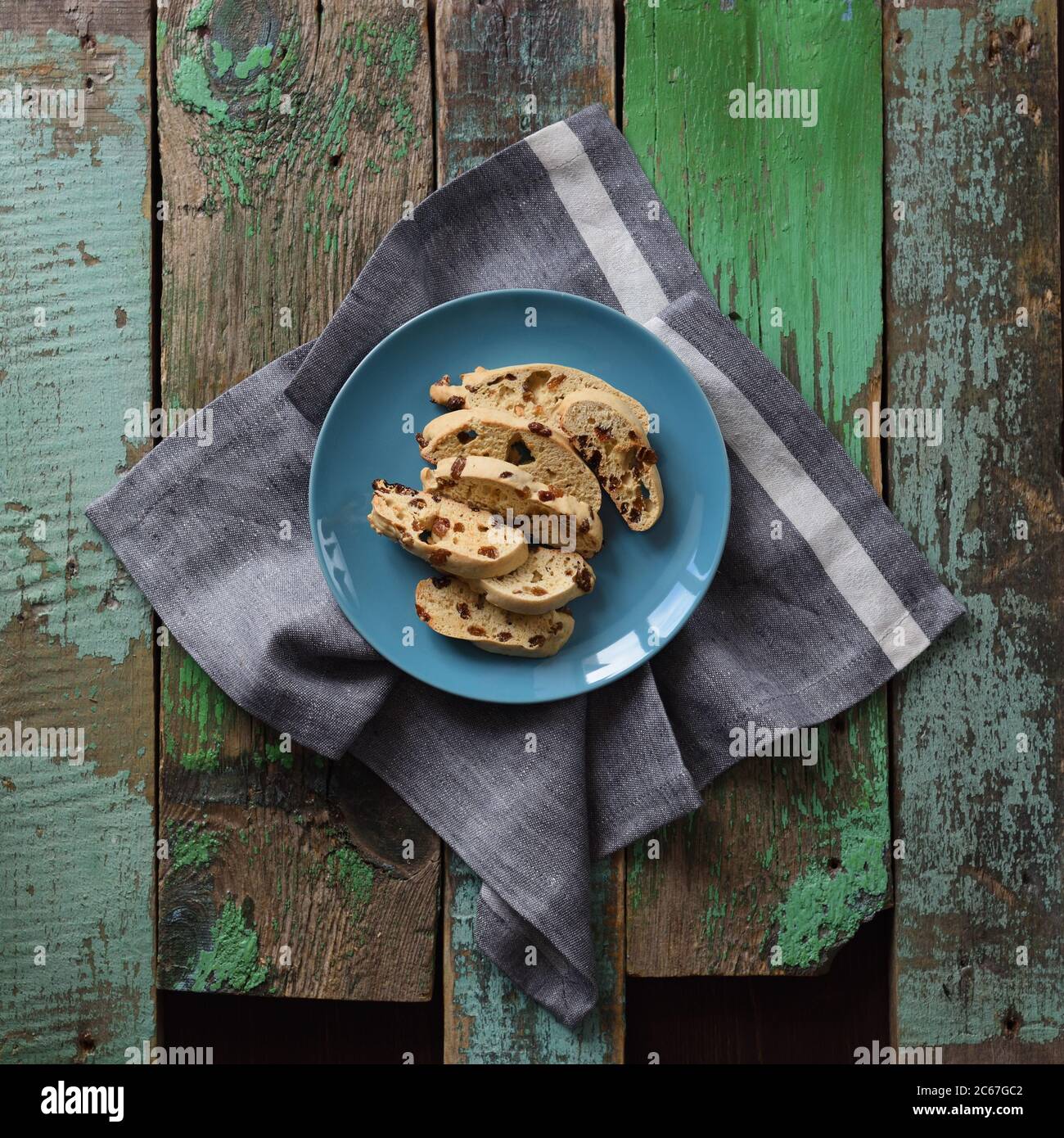 Homemade delicious pastry carquinyoli or biscotti with raisins in blue plate on old green wooden boards top view copyspace Photo - Alamy