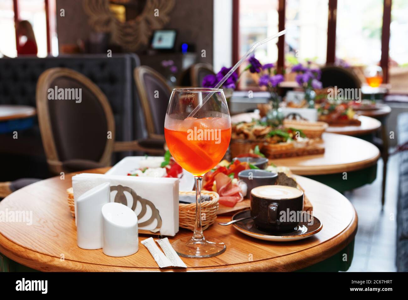Spritz fizz cocktail and various Italian food on restaurant table, toned Stock Photo