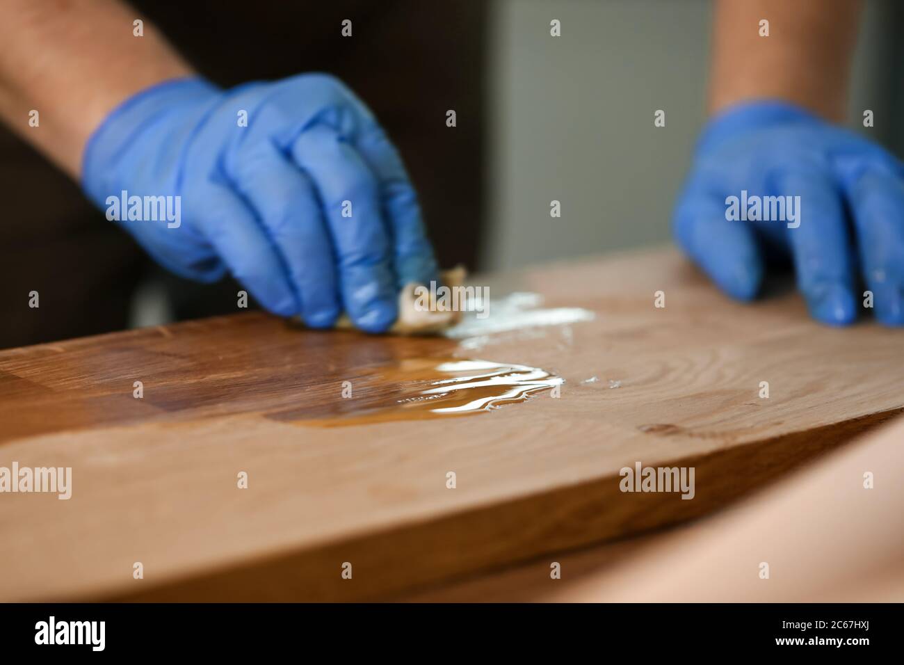Man varnishing table at workshop Stock Photo