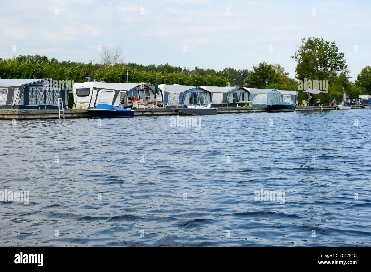 National Park Weerribben-Wieden, The Netherlands: People camping with a caravan next to a lake in National Park Weerribben-Wieden, The Netherlands Stock Photo