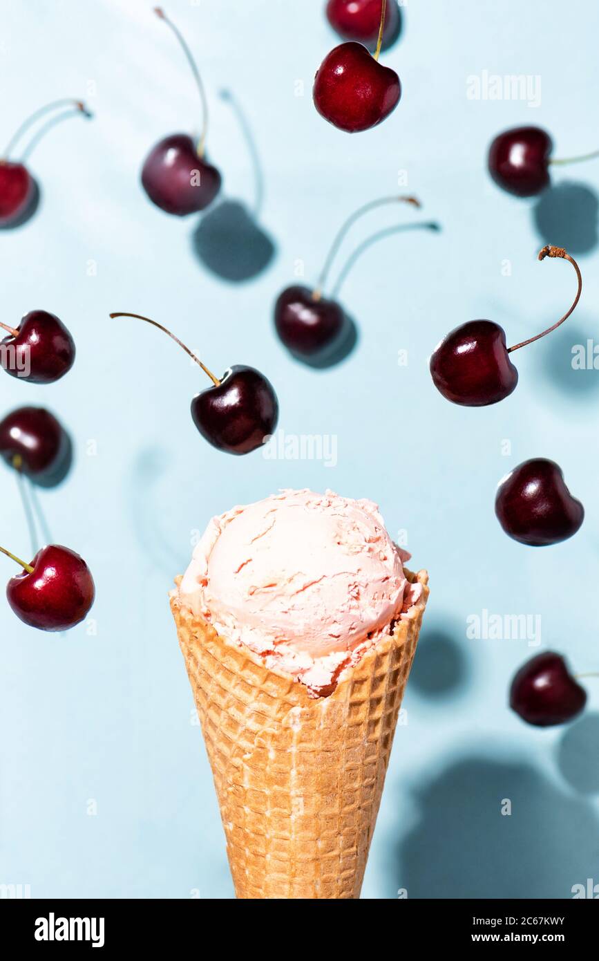 Flying pink sweet cherry ice cream cone in motion Stock Photo