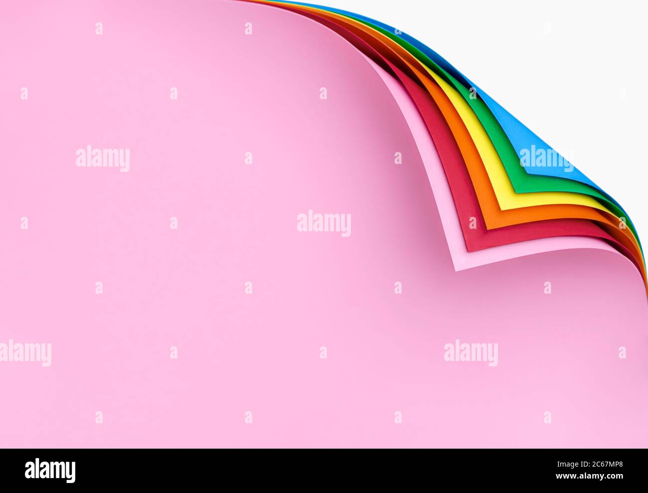 Stack of rainbowcolored paper sheets with curled corners. Multicolor