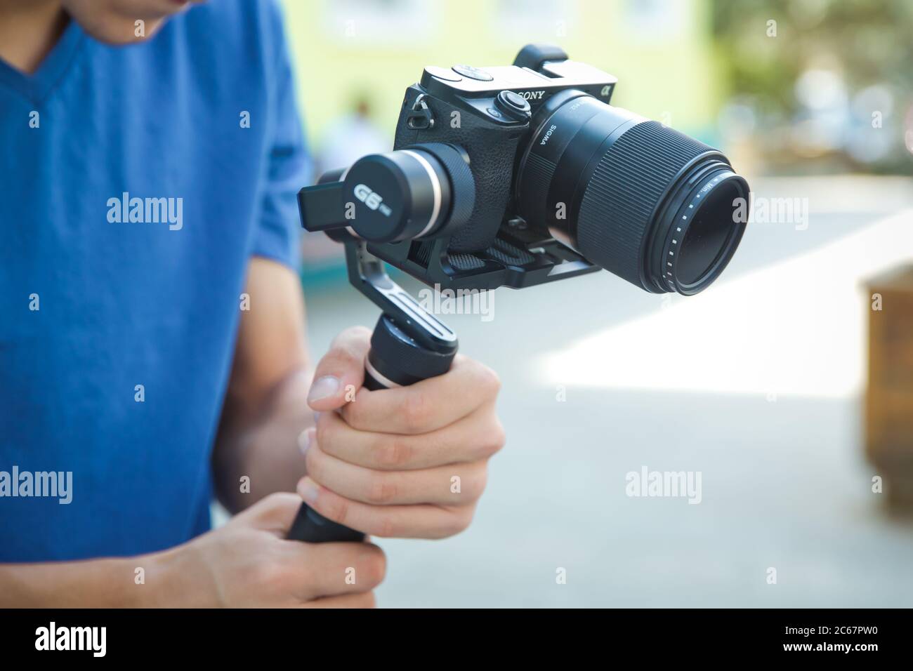 Gimbal Operator with black equipament - Stabilizer and camera filmmaking . An unidentified man holding gimbal a camera stabilizer . Man holding gimbal Stock Photo