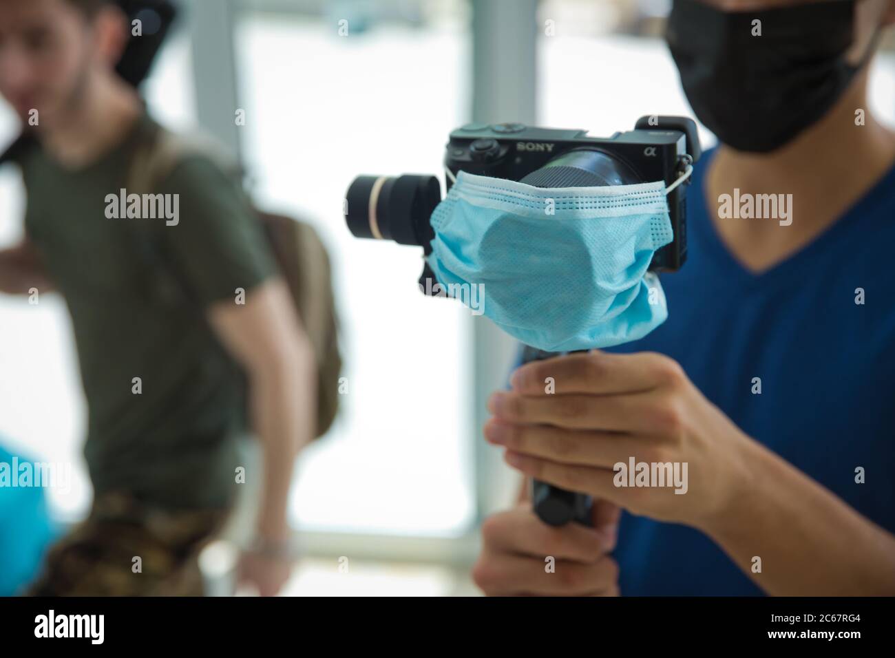 Gimbal Operator with black equipament - Stabilizer and camera filmmaking . An unidentified man holding gimbal a camera stabilizer . Man holding gimbal Stock Photo