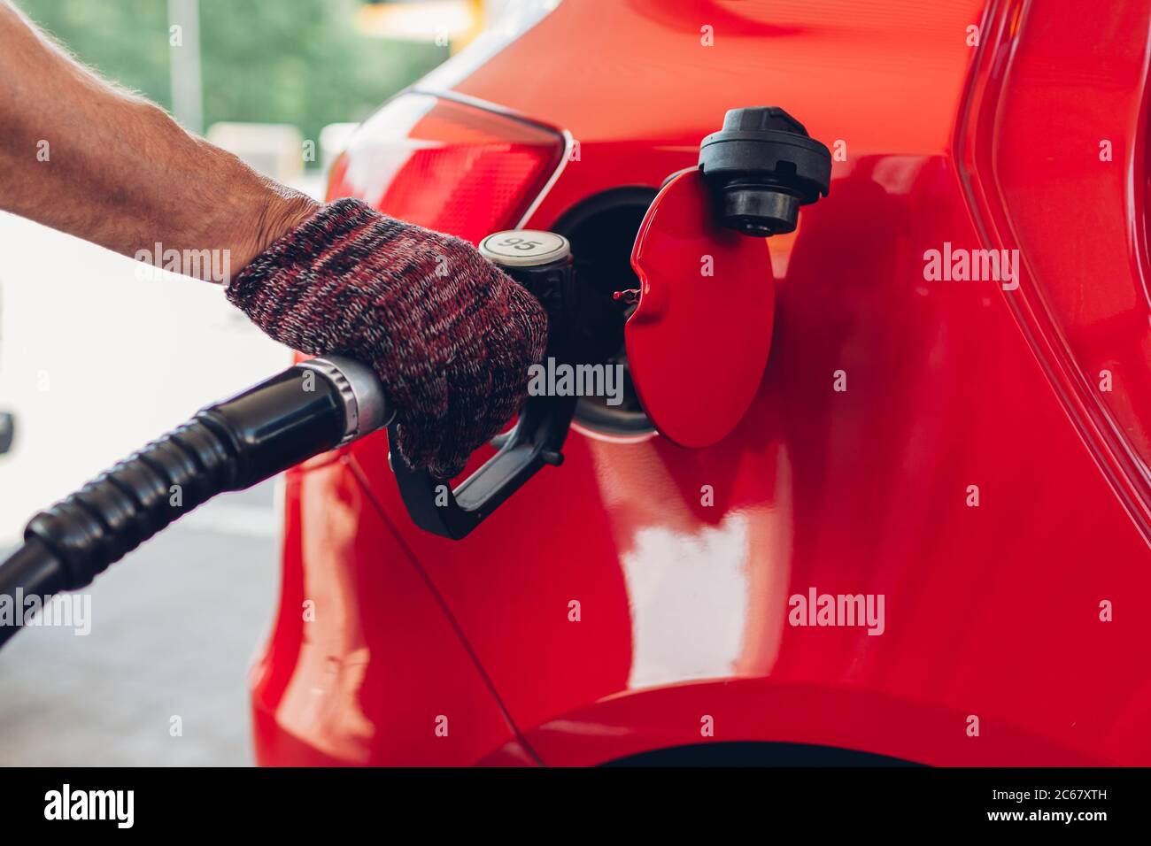 Man pumping gas fuel into car tank at filling station. Petrol station