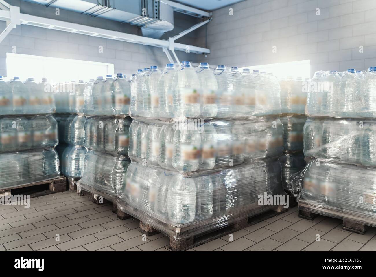Plastic bottles with a drink on pallets in warehouse ready for