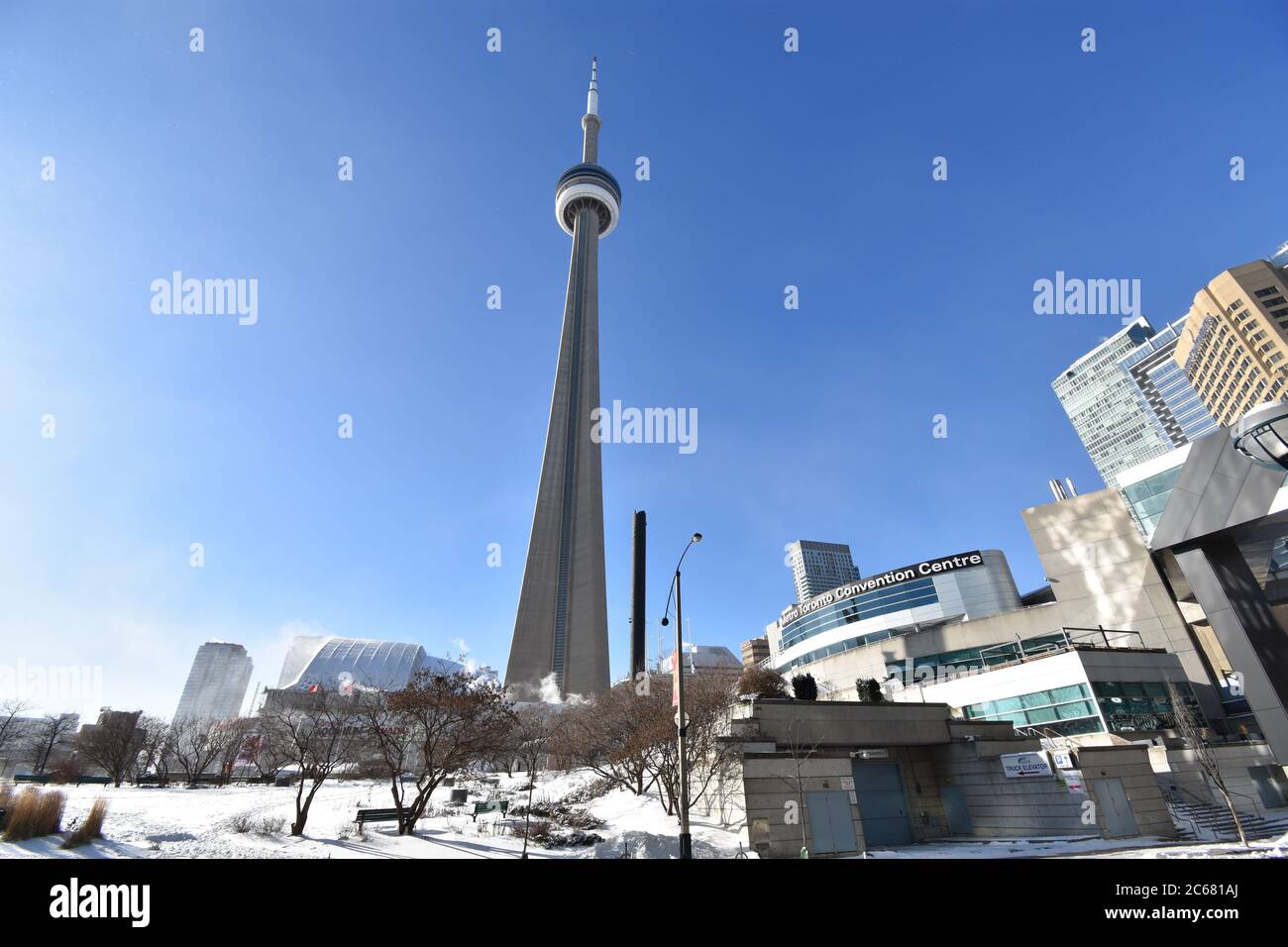 Looking up at the CN tower from Lower Simcoe Street on a clear winters morning.  The Metro convention Centre and Ripley's Aquarium is visible. Stock Photo