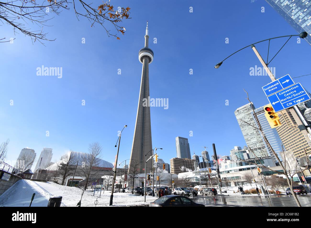 The CN tower from Lower Simcoe Street on a clear winters morning.  The Metro convention Centre, Ripley's Aquarium and street signs are visible. Stock Photo