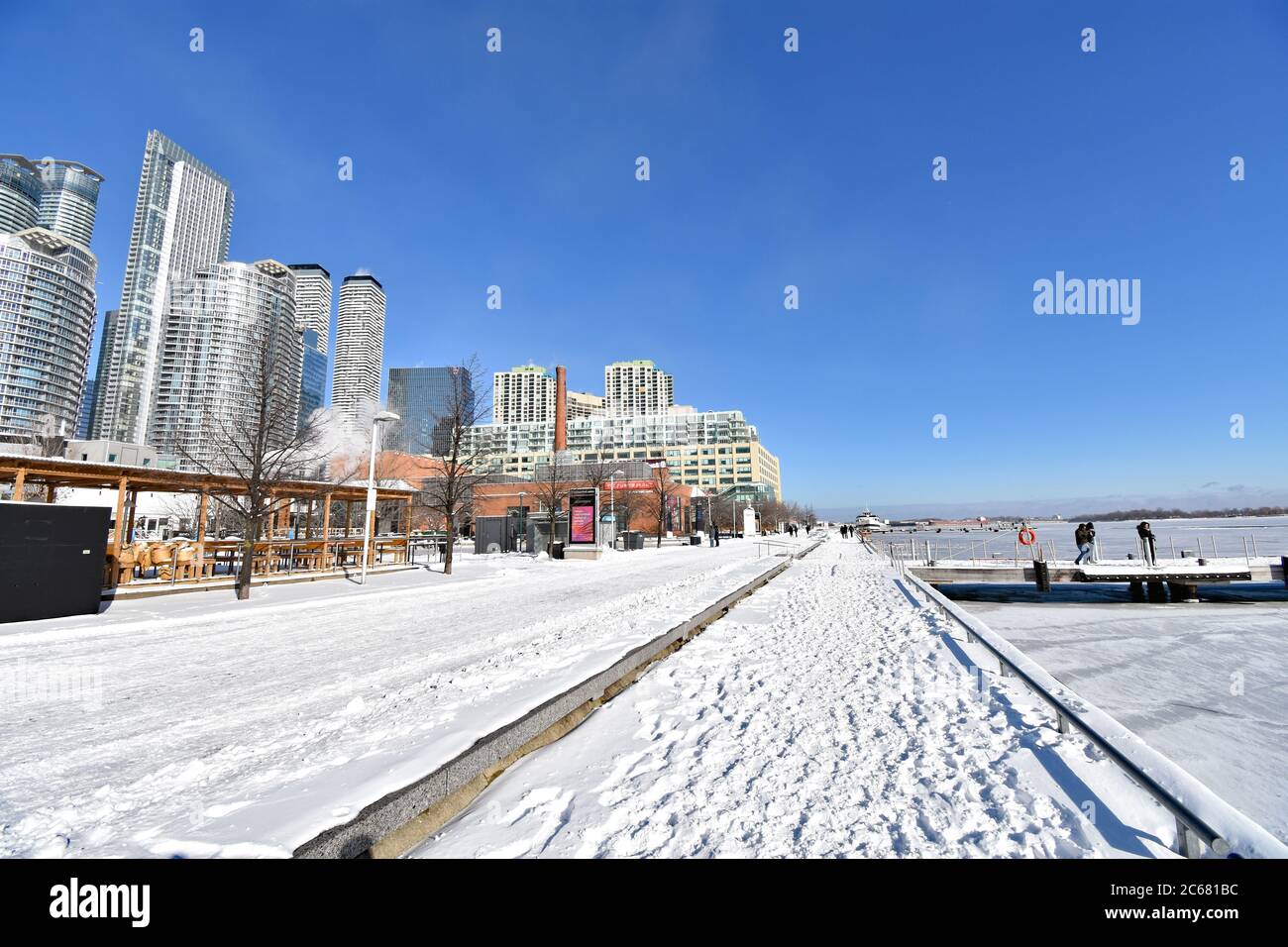The Waterfront Trail at the Harbour Front Centre in Toronto.  Snow is on the ground and Lake Ontario has frozen over in the winter weather. Stock Photo
