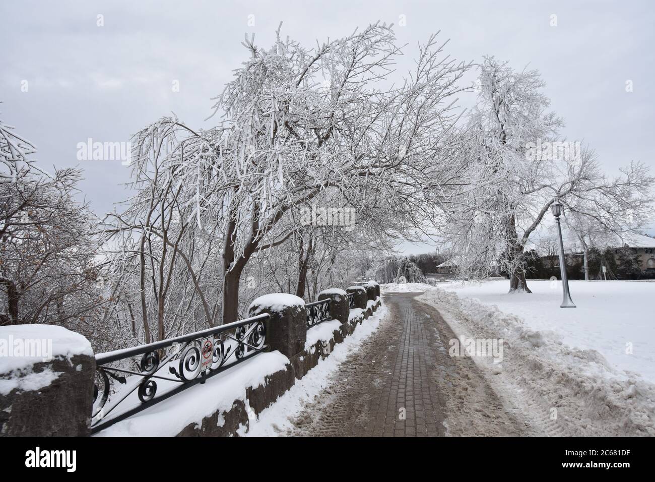 The riverside path in Queen Victoria Park during wintertime at Niagara Falls on the Canadian side. Trees have become white due to snow and ice. Stock Photo