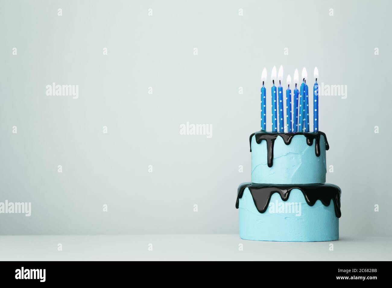 Blue tiered birthday cake with eight candles Stock Photo Alamy