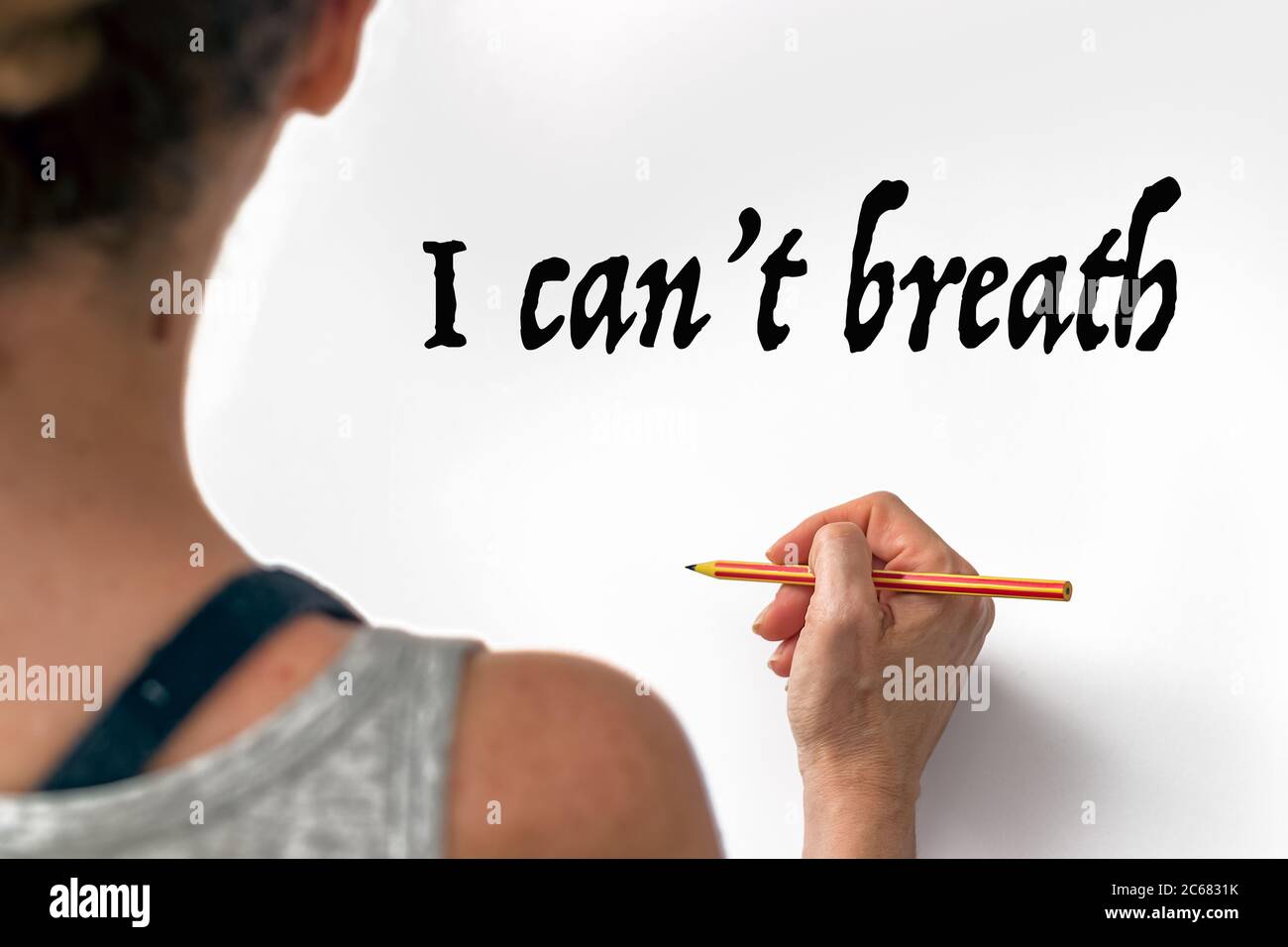Female hand writting the phrase I Can't Breath on a white paper, indoors. Anti-racist concept Stock Photo