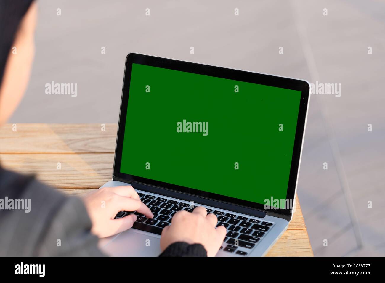 over should of woman using green screen laptop computer on sunny day. blur background Stock Photo