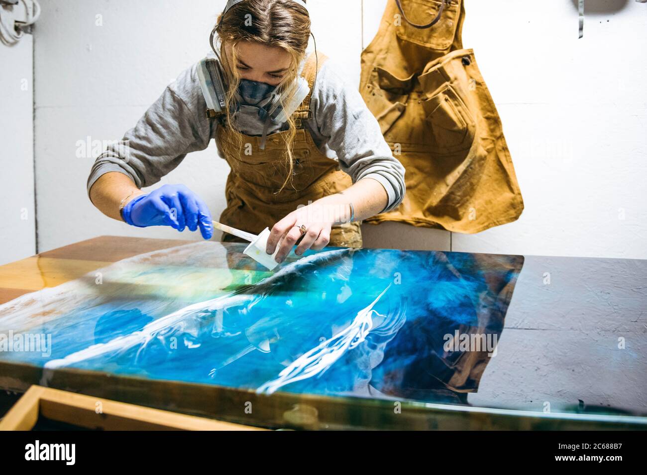 Female resin artist using simple materials to perfect artwork Stock