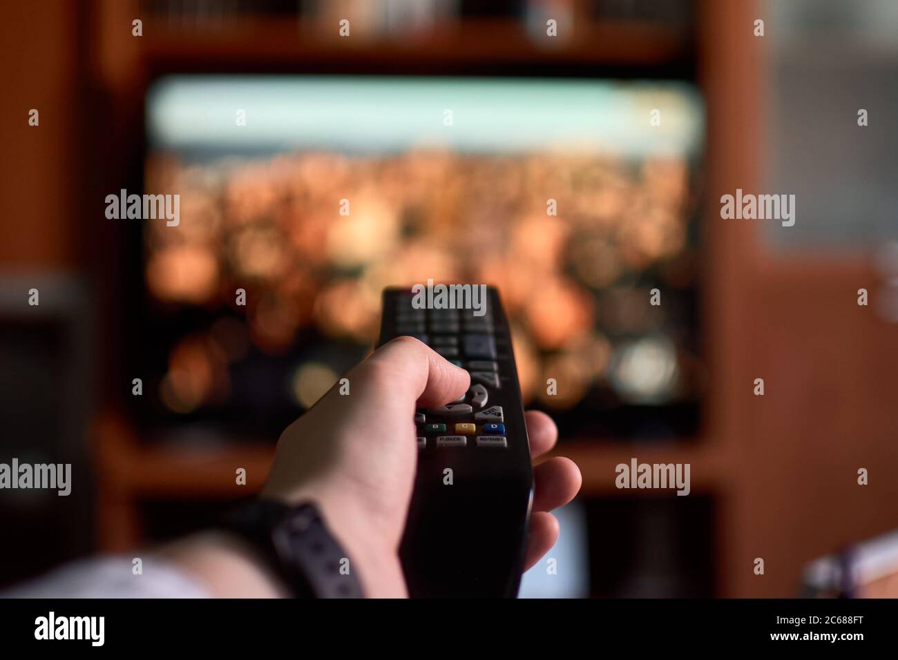 Close-up of a man changing channels with a remote control at home Stock Photo