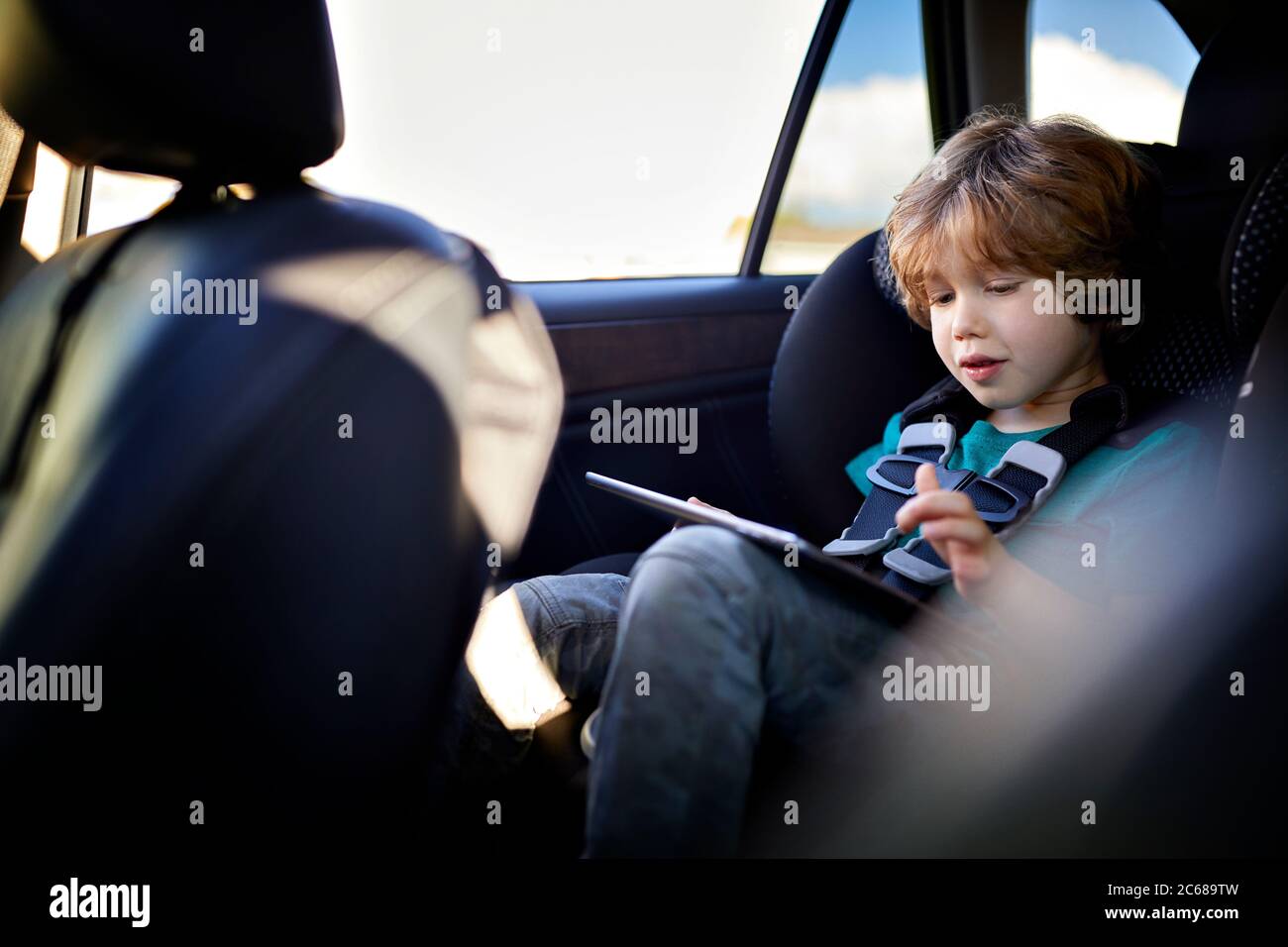 Cute boy using tablet PC while traveling in car Stock Photo