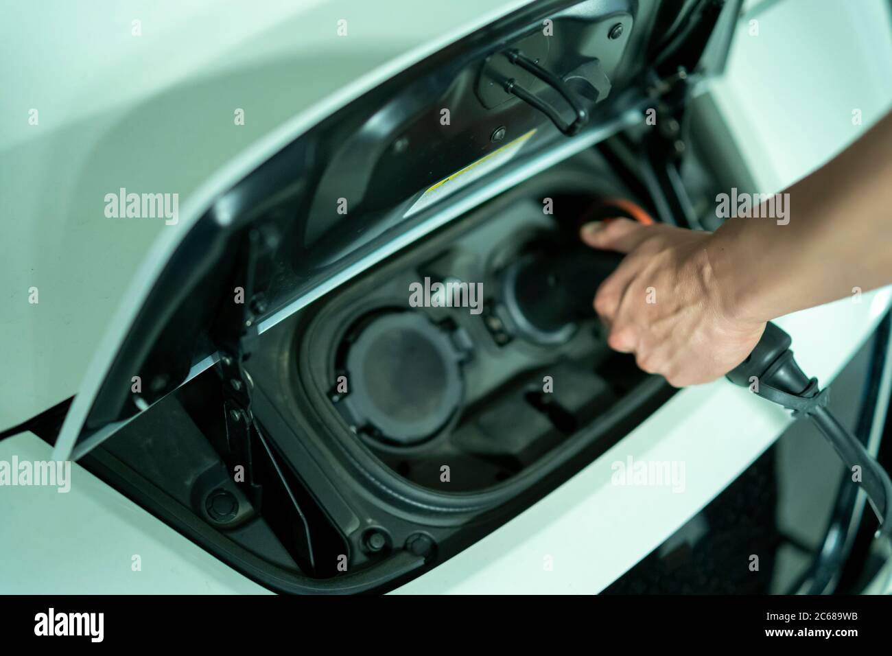 young man charging his nonpolluting electric vehicle Stock Photo Alamy