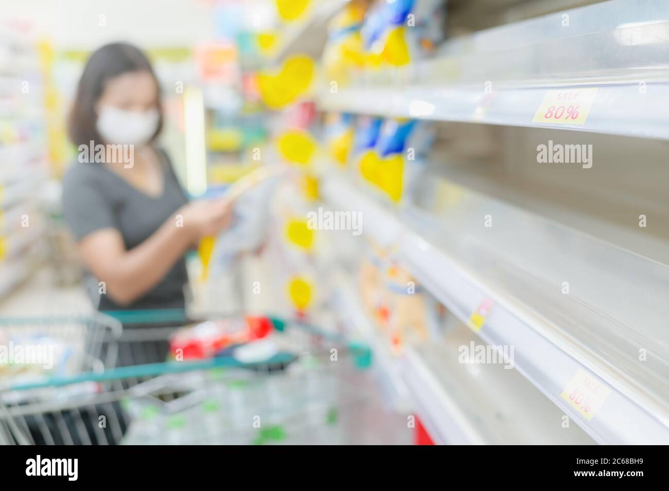 Empty shelves in a supermarket. Customers buy groceries and other items
