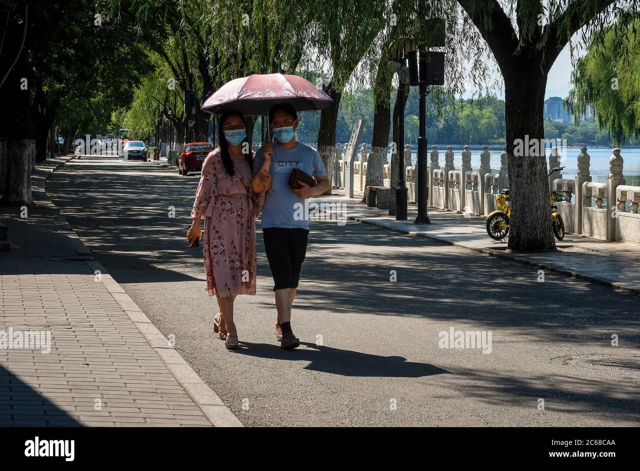 Beijing, China. 07th July, 2020. Couple walks at usually busy touristic area of Houhai lake in Beijing, China on 07/07/2020 The Chinese capital took strict measures to stop the spread of Covid-19 as new cases of coronavirus disease (COVID-19) were reported in June. by Wiktor Dabkowski | usage worldwide Credit: dpa/Alamy Live News Stock Photo