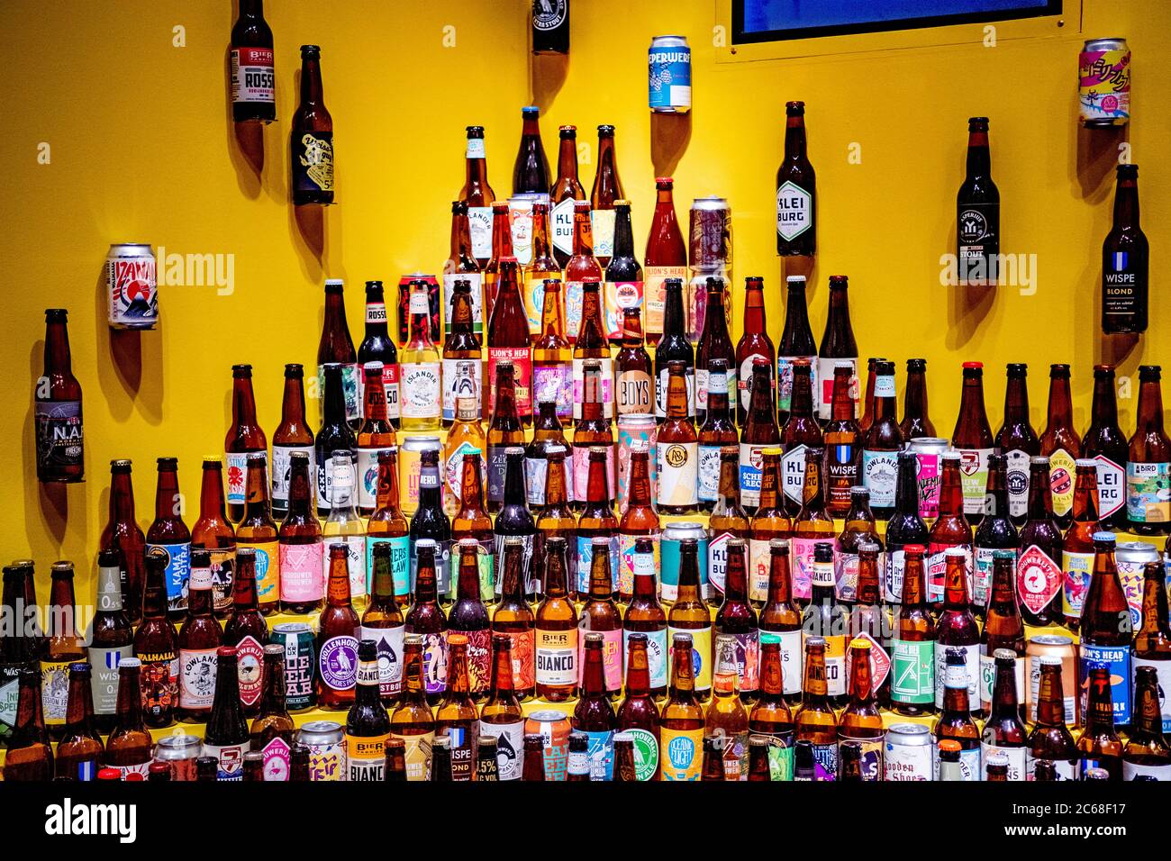 A wall decorated with beer bottles during the beer exhibition.Amsterdam Museum presents the exhibition Beer.  Amsterdam is known as the city of beer and brewers. In the exhibition Beer, visitors can learn all about the capital's beer history. Many Amsterdam mayors were brewers, breweries such as Heineken once started there and today the city has no less than 45 beer breweries. Stock Photo
