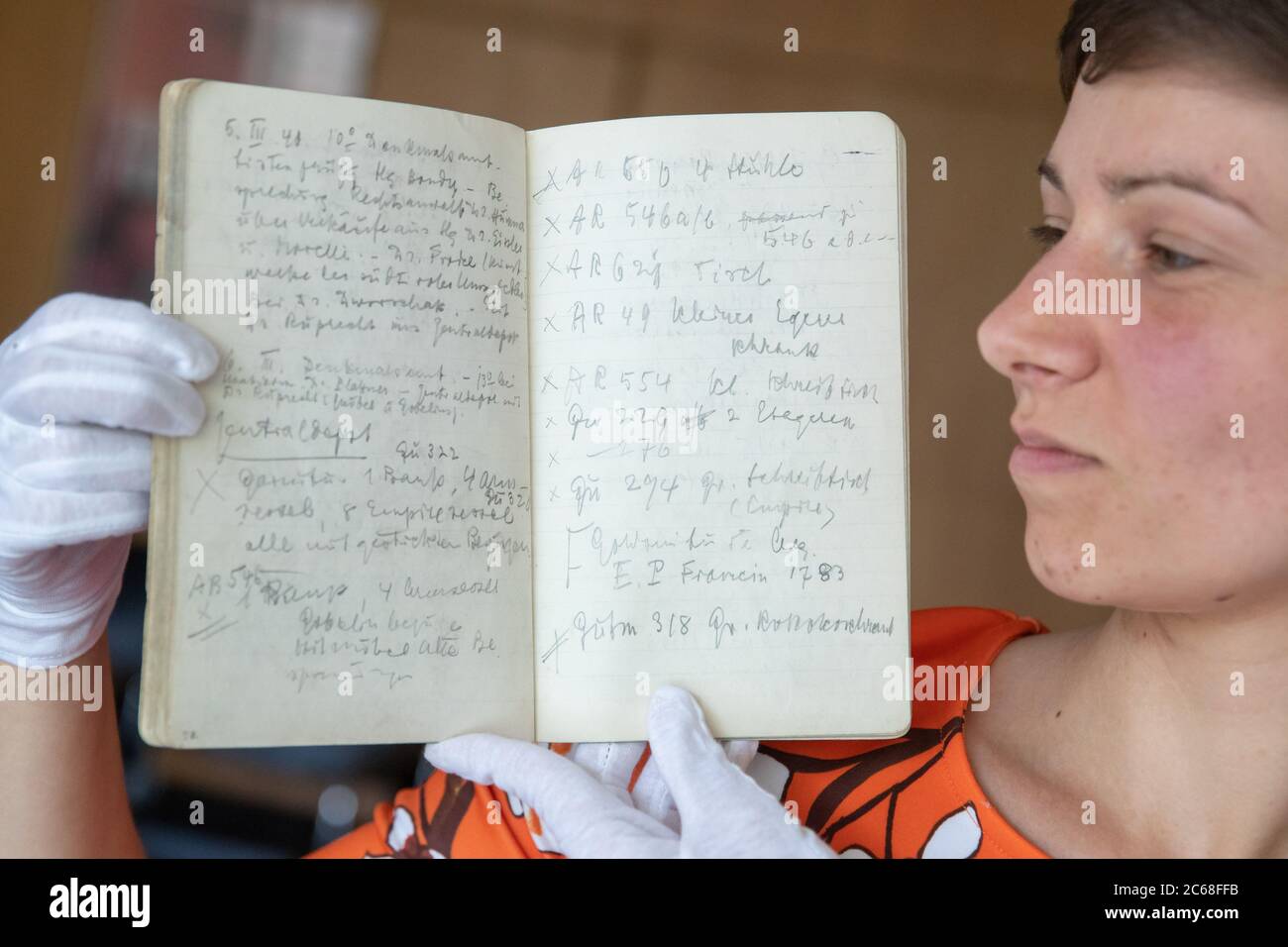 06 July 2020, Bavaria, Nuremberg: Frederike Uhl, research assistant in the Posse Editions project at the Germanisches Nationalmuseum, holds an original service diary by Hans Posse with his notes in her hands. Posse was Hitler's former special envoy. On his business trips he got a good overview of the looted works of art of the National Socialists. Over the past three years, researchers at the Germanisches Nationalmuseum in Nuremberg have deciphered the elusive notes of Hans Posse's business trips. (to dpa 'Diaries bring new insights into NS art theft') Photo: Daniel Karmann/dpa Stock Photo