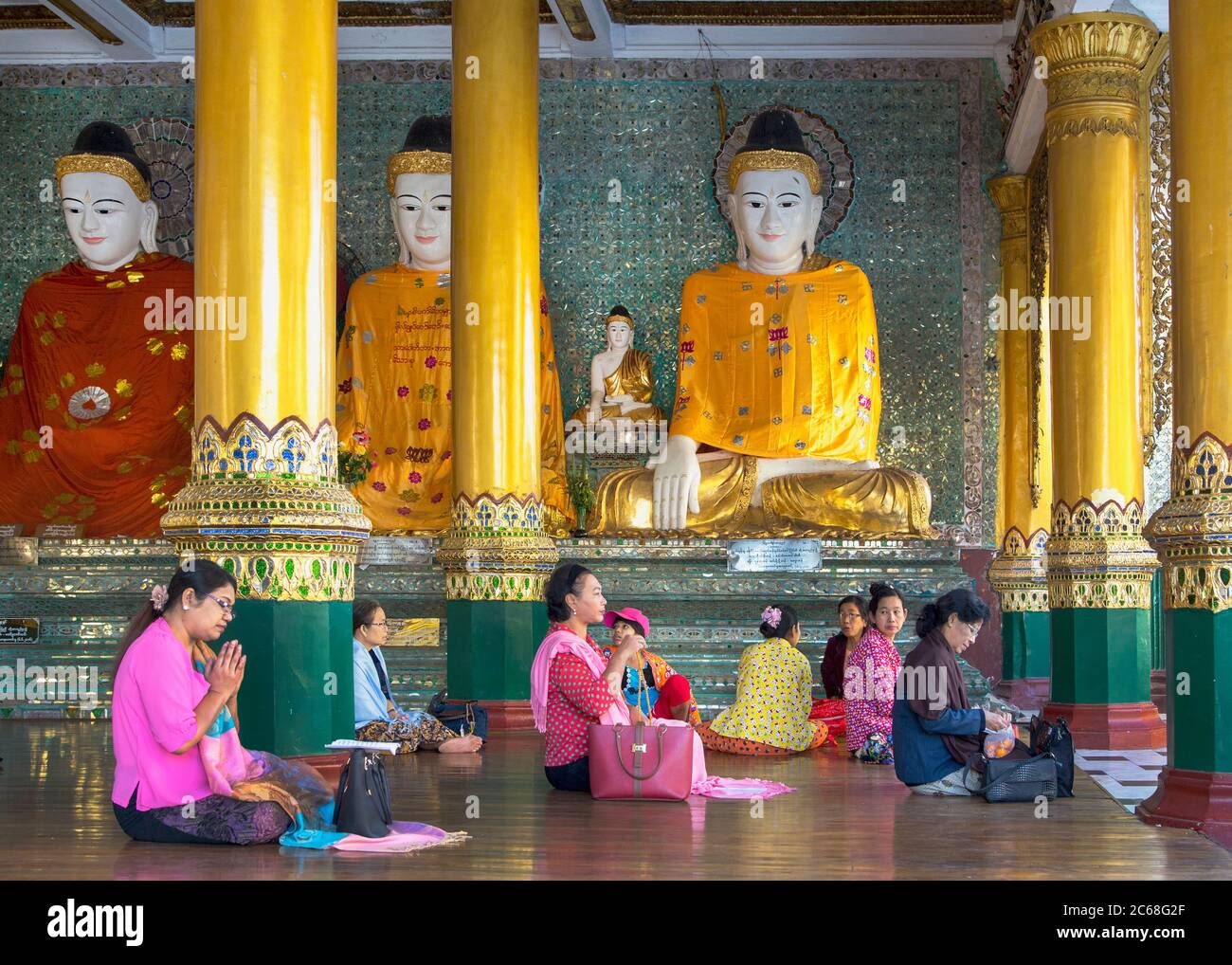 Worshippers with Buddha Statues in the Shwedagon Pagoda, Yangon, Myanmar Stock Photo