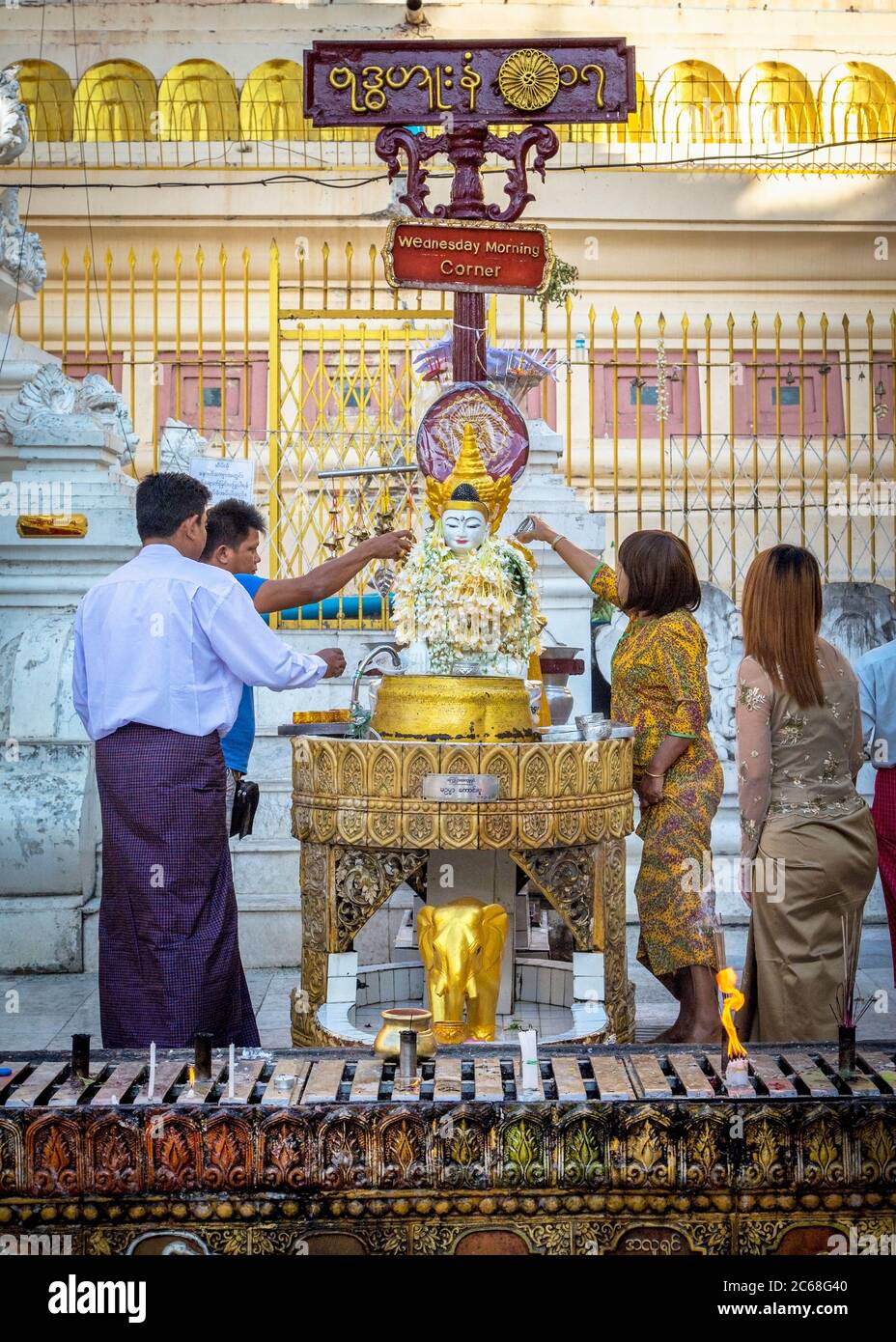 Devotees make offerings at the Wednesday Morning Shrine in the Shwedagon Pagoda, Yangon, Myanmar Stock Photo