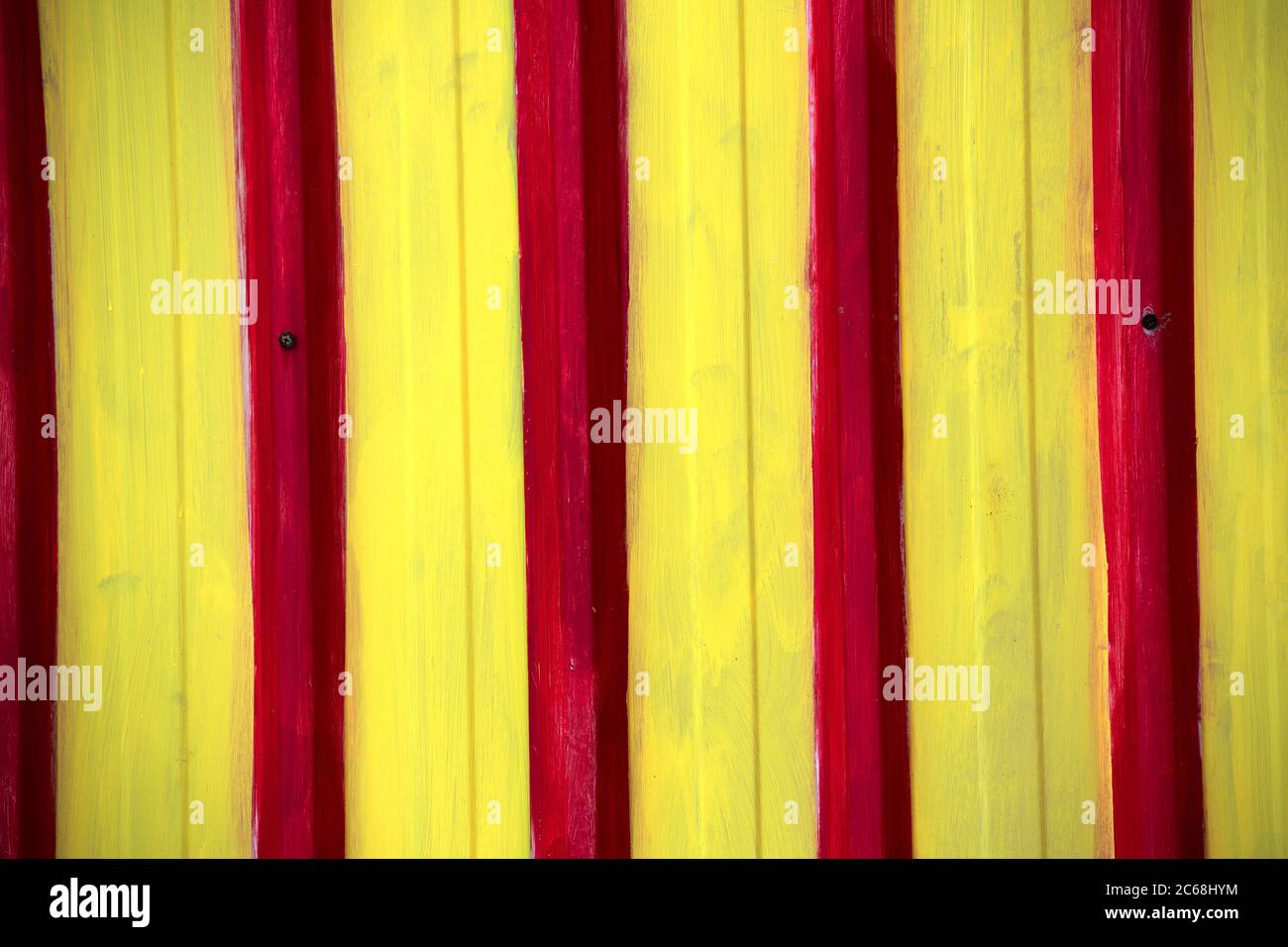 red and yellow painted corregated tin wall on side of beach hut north west tasmania australia Stock Photo