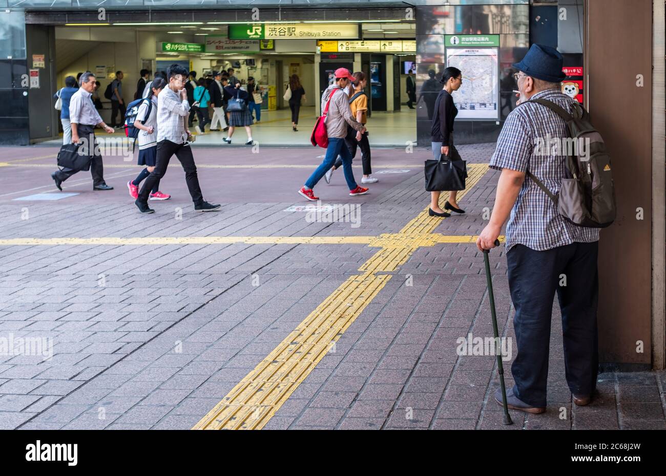 Elderly man with a walking cane in Hachiko square, Tokyo, Japan Stock Photo