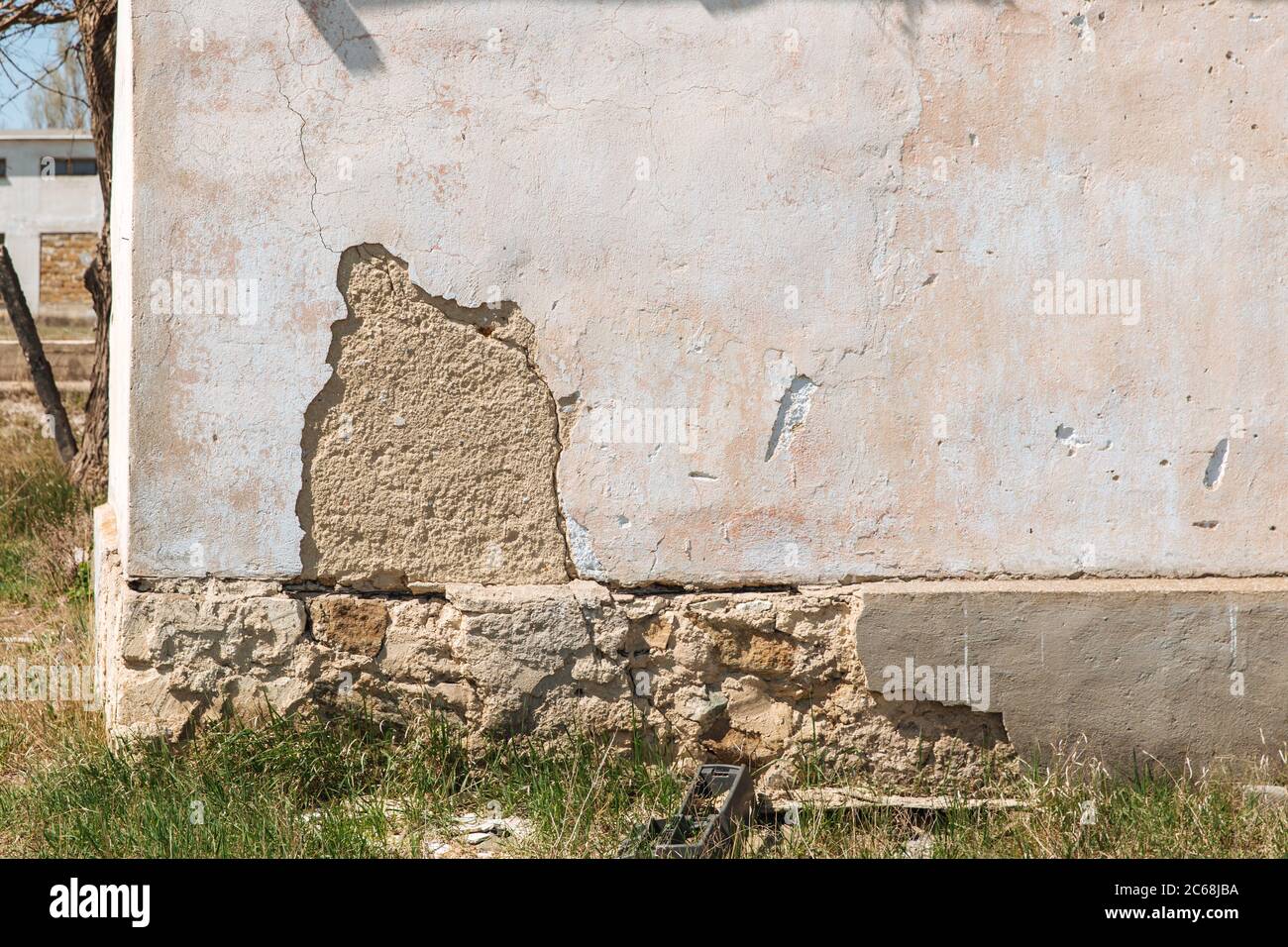 Plaster peeling off brick wall. The foundation of a residential