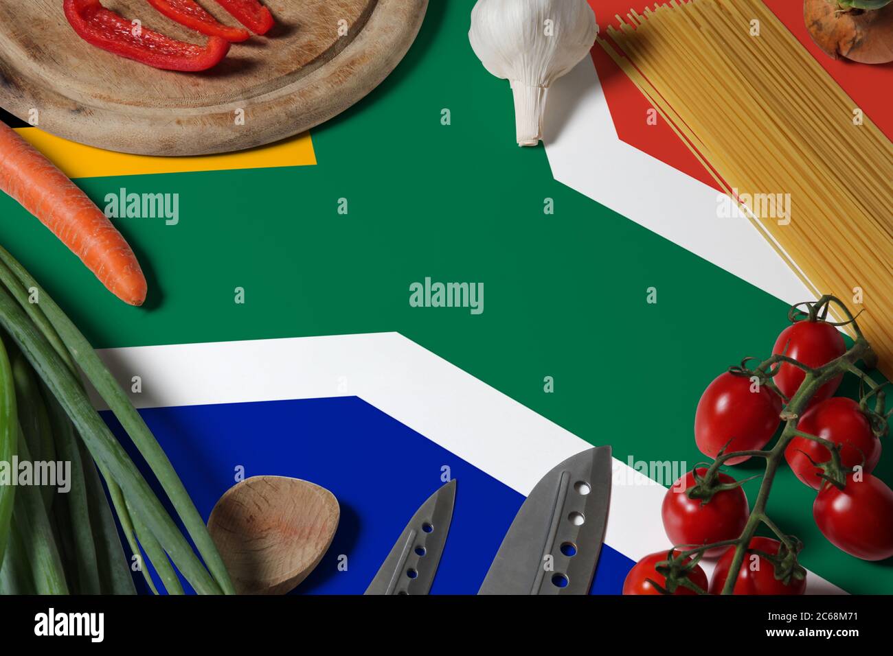 South Africa flag on fresh vegetables and knife concept wooden table. Cooking concept with preparing background theme. Stock Photo