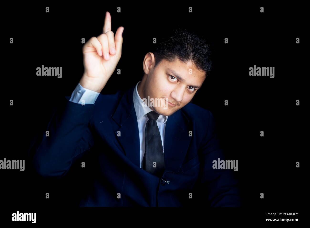 Classy careless focused CEO entrepreneur isolated over black background in blue classy suit, focusing on goal leaving distractions behind. Stock Photo