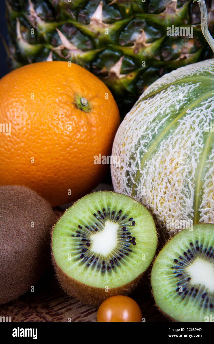 A honeydew melon, a pineapple, chopped kiwi, an orange and some Chinese