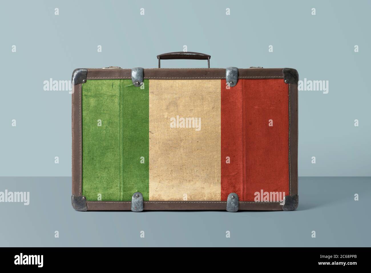 Italy flag on old vintage leather suitcase with national concept. Retro