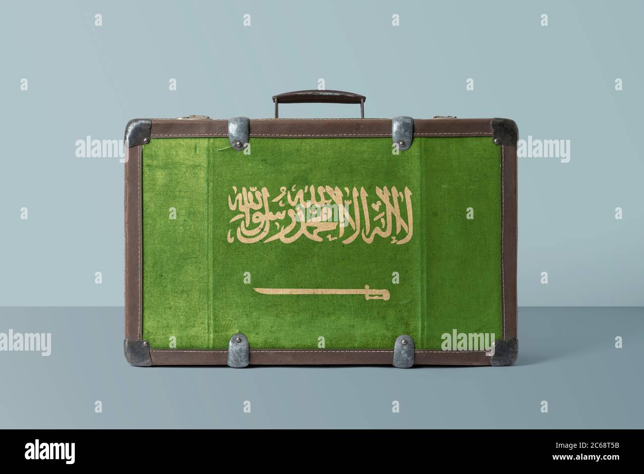 Saudi Arabia flag on old vintage leather suitcase with national concept
