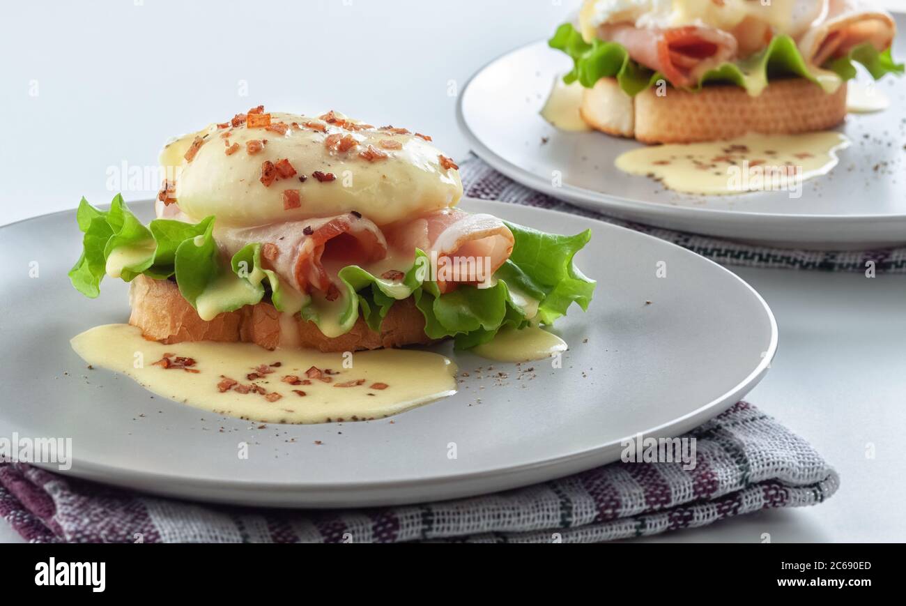 Eggs Benedict on toasted muffins with ham and sauce Stock Photo