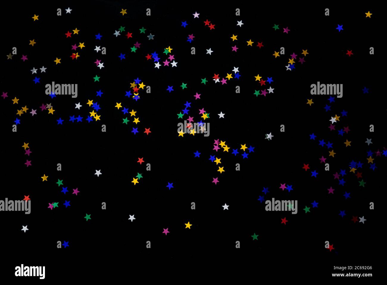 Multi-colored stars on a black background. Festive background of ...