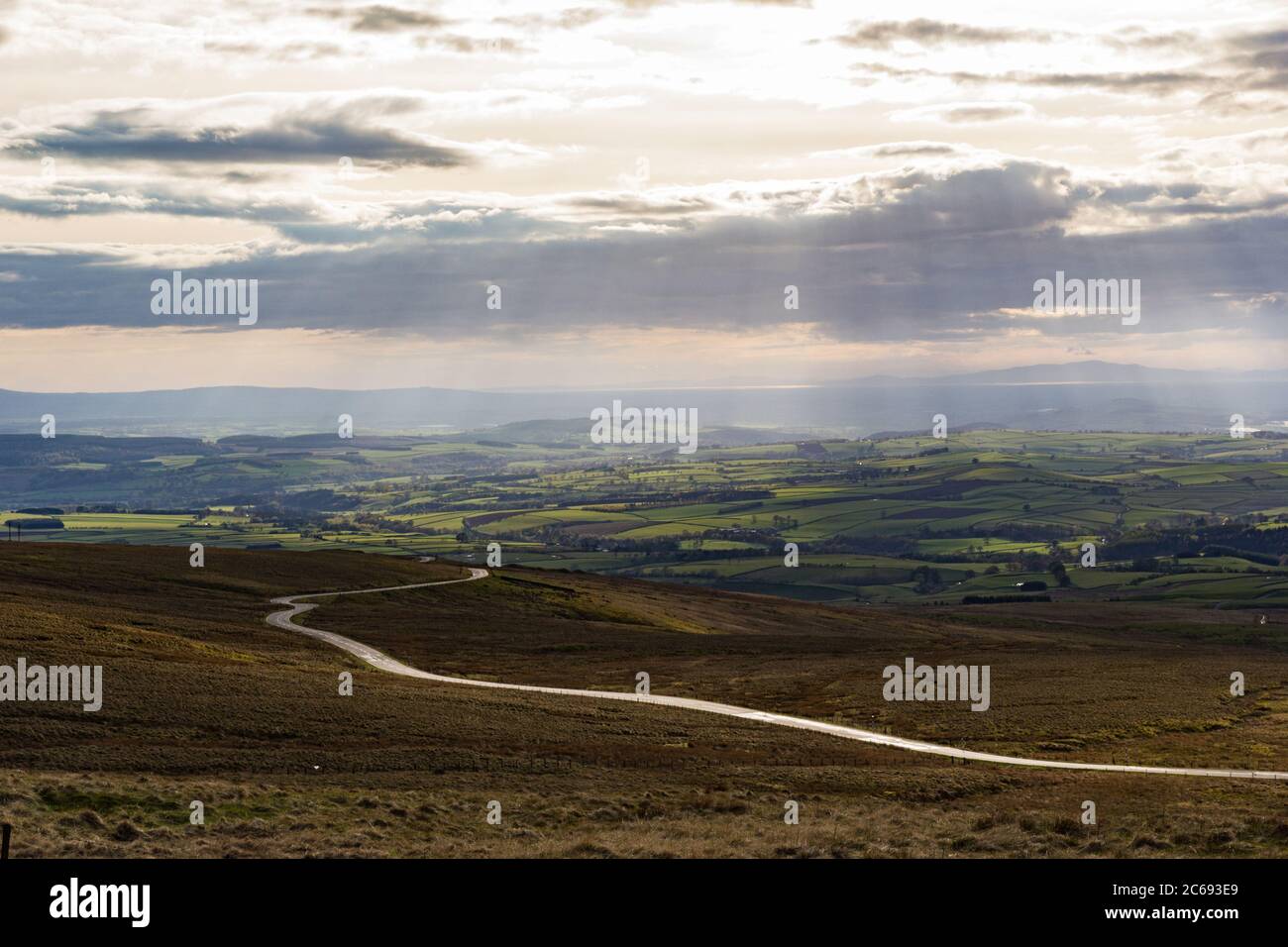 Cumbrian Landscape, Eden Valley, and distant Lake District hills taken from Hartside Top near Alston in the Pennines with rays from the setting sun br Stock Photo