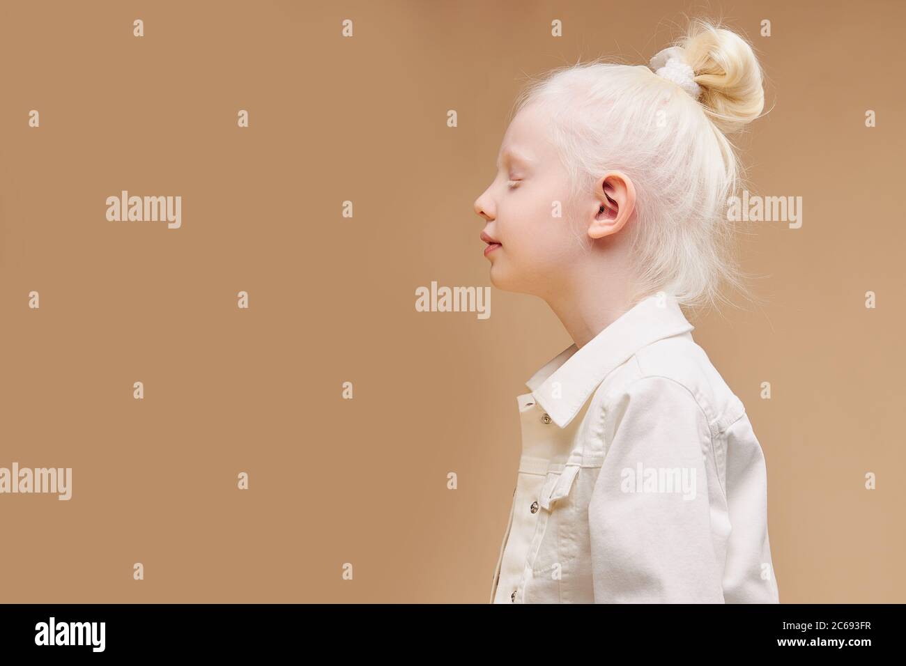 side view on strange little caucasian girl with unusual appearance, she has pale skin and white hair, alien concept. natural beauty, people diversity Stock Photo