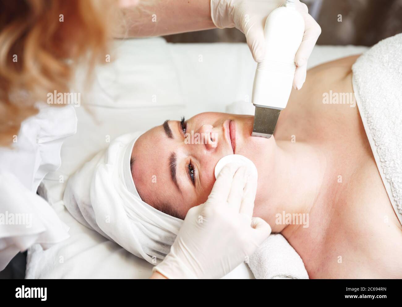 Doctor doing procedure of ultrasonic cleaning of face. Skin Cleansing