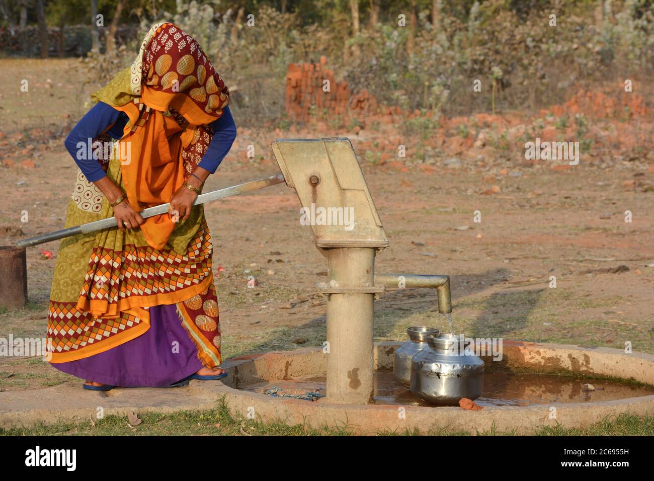 TIKAMGARH, MADHYA PRADESH, INDIA - MARCH 24, 2020: Unidentified Indian woman using hand pump for drinking water. Stock Photo