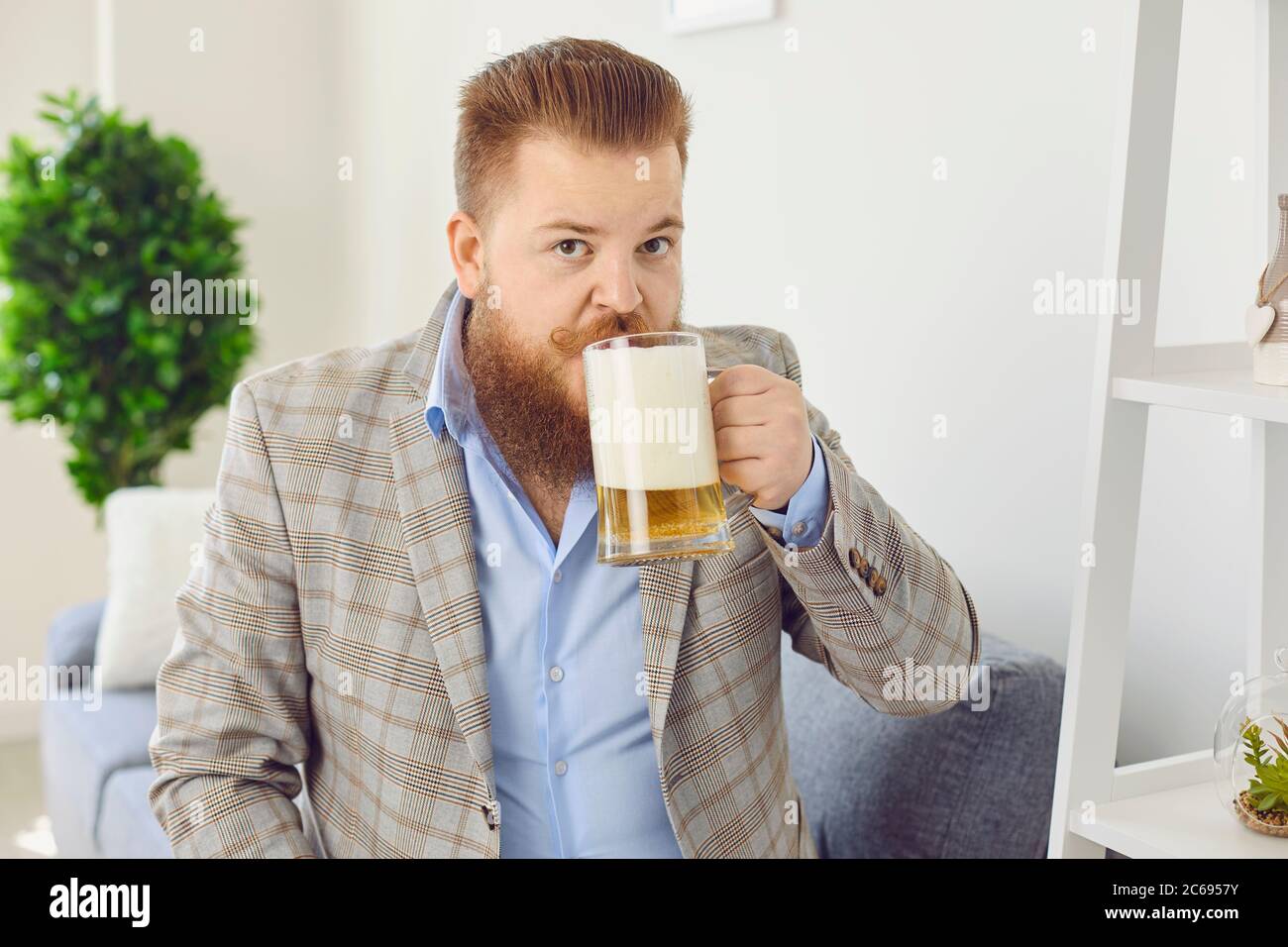 Online looking at camera. Funny man with a glass of beer smiles at friends online video chat call webcam conference home application. Stock Photo