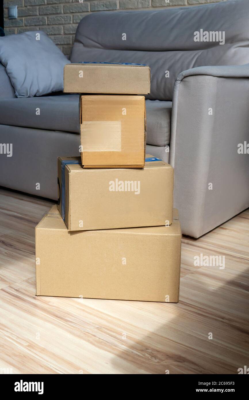 Delivery boxes stack on the floor. Home interior, sofa on background ...
