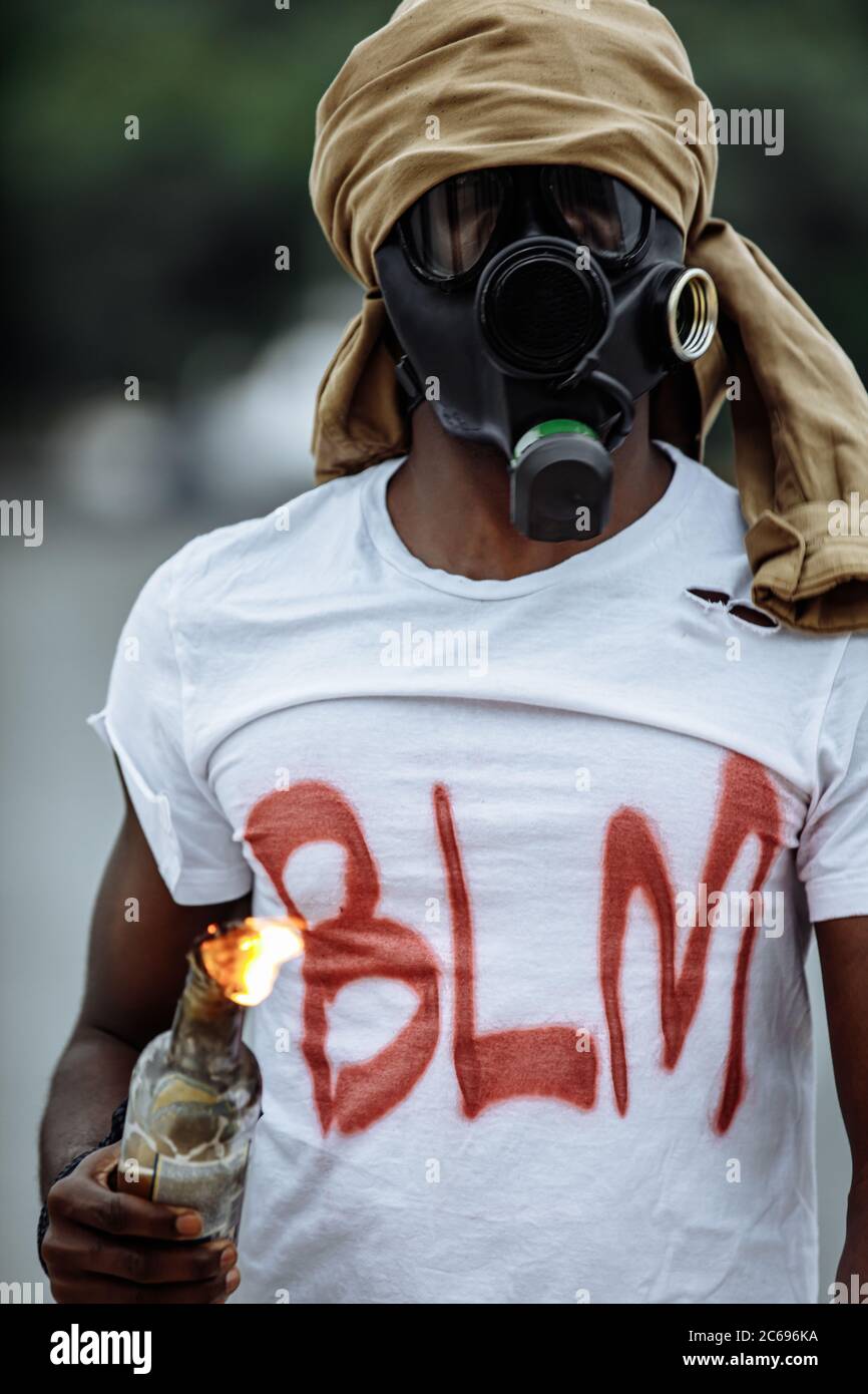 portrait of young african american black man in gas mask in the streets ...